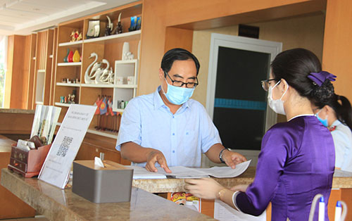 Ông Lâm Hoàng Dũng, Phó Giám đốc Trung tâm Kiểm soát bệnh tật, kiểm tra quy trình đón và phục vụ khách tại quầy tiếp lễ tân Khách sạn Nesta Cần Thơ.